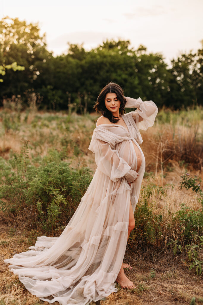 An expecting mother in a flowy gown at sunset in Northwest Community Park. 